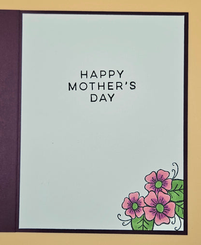 Mother's Day card with flowers and 'Happy Mother's Day' text on a light blue background.