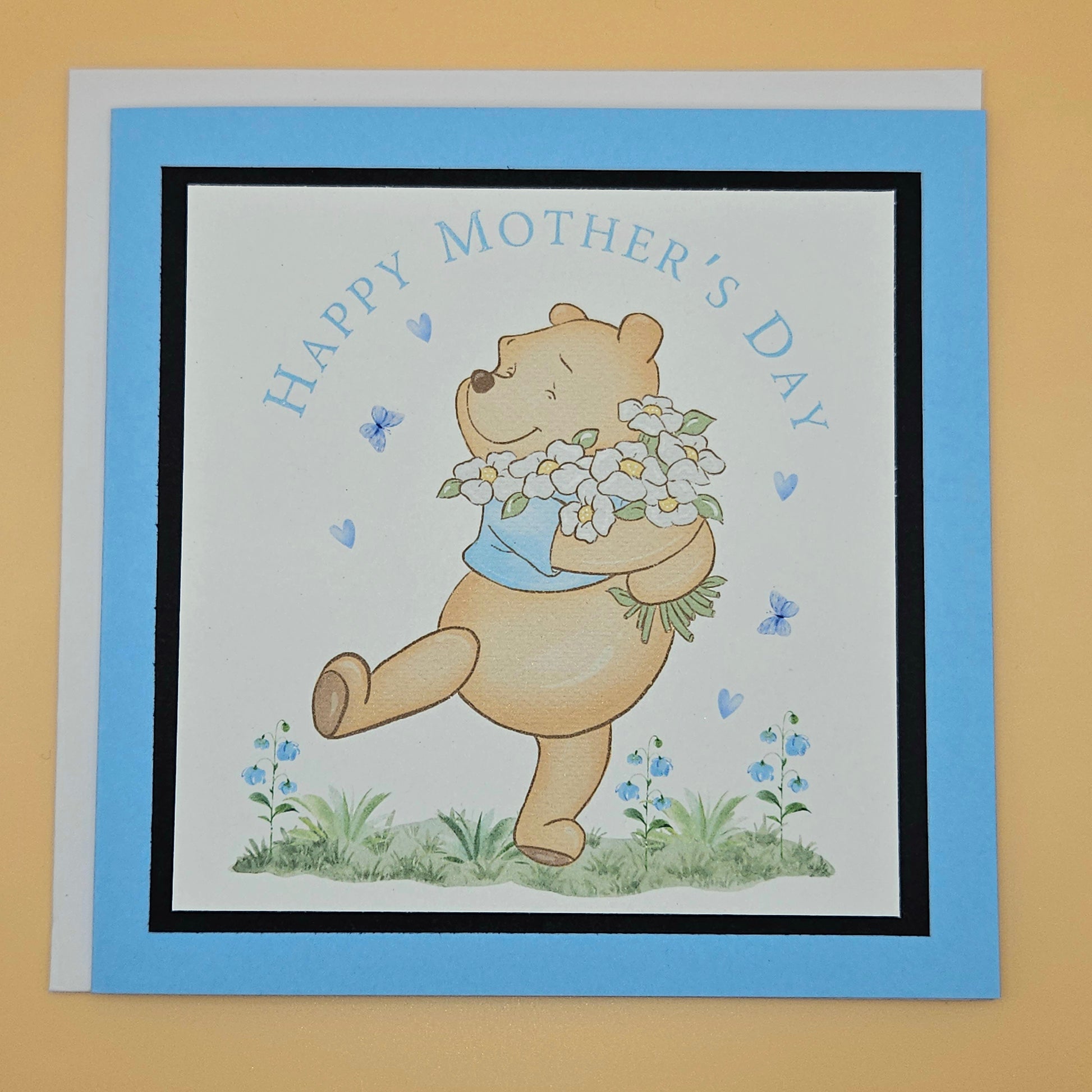 Mother's Day card with a bear holding flowers on a beige background