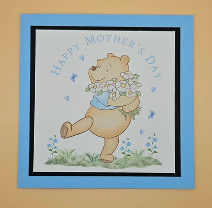 Card with a bear holding flowers and 'Happy Mother's Day' text on a beige background