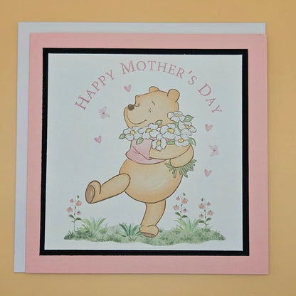 Mother's Day card with a bear holding flowers on a pink border