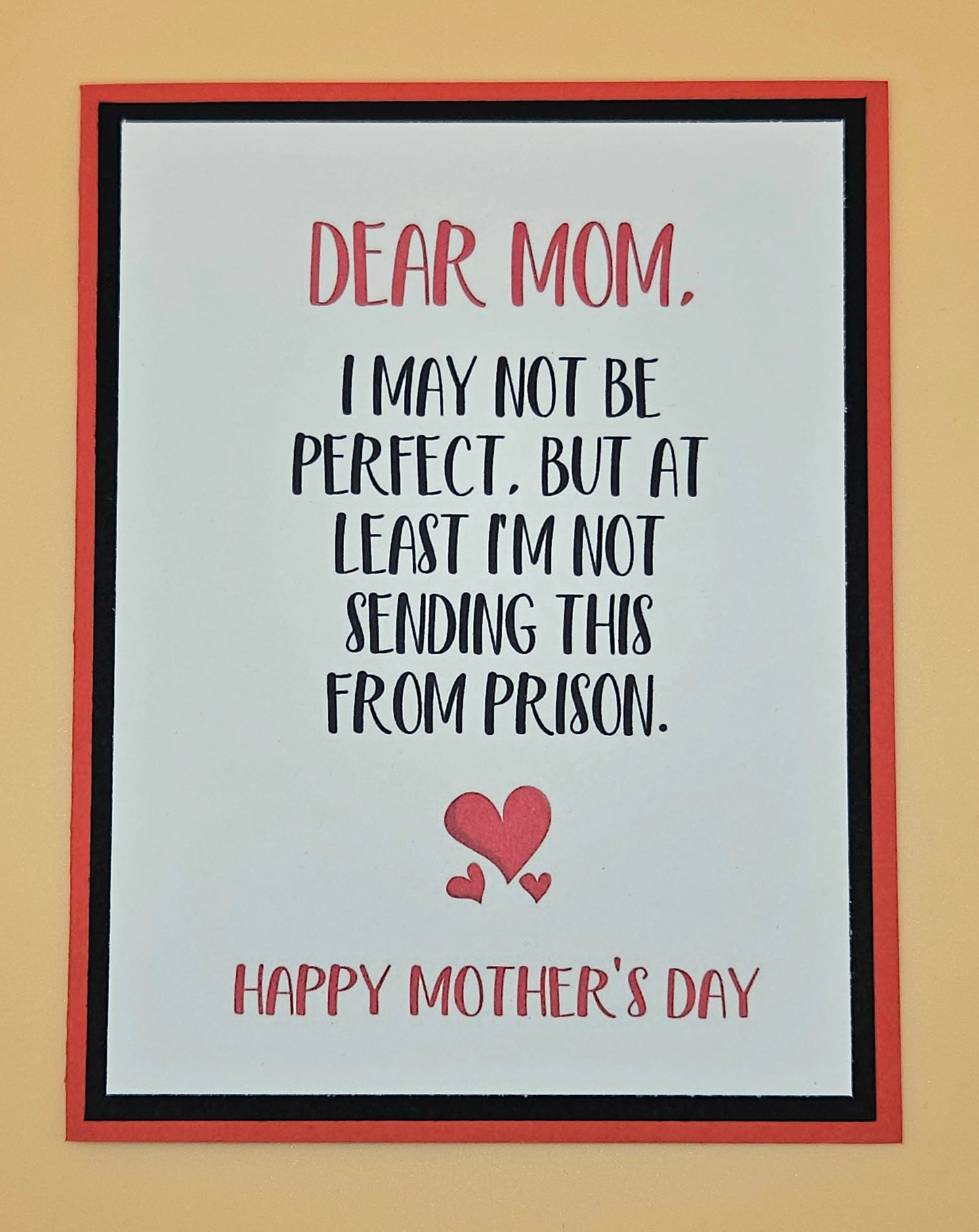 Framed Mother's Day card with humorous message and heart design on a beige background