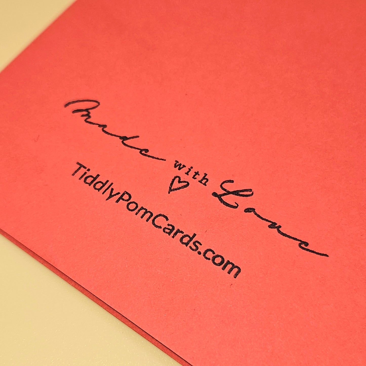 Red card with 'Made with Love' text and website URL on a beige background