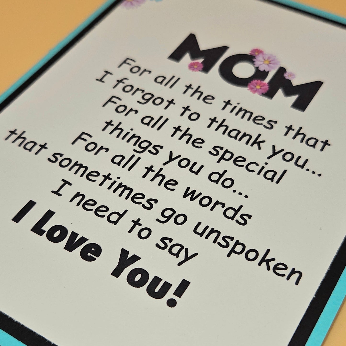 Card with text for mom expressing love and gratitude on a wooden surface