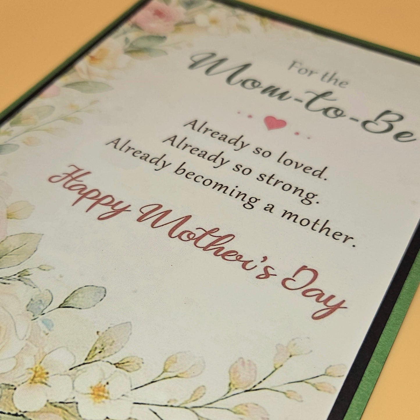 Greeting card for a soon-to-be mother with floral designs and text on a light background.