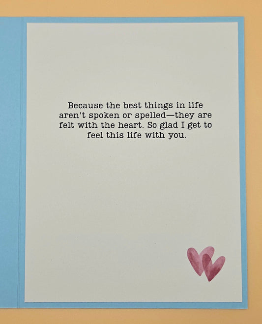 Card with a romantic quote and two hearts on a beige background