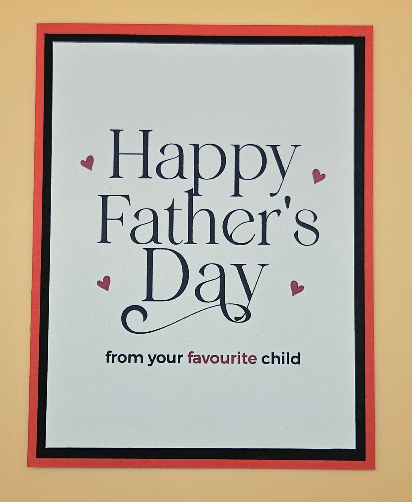 Framed card with 'Happy Father's Day from your favourite child' text on a beige background