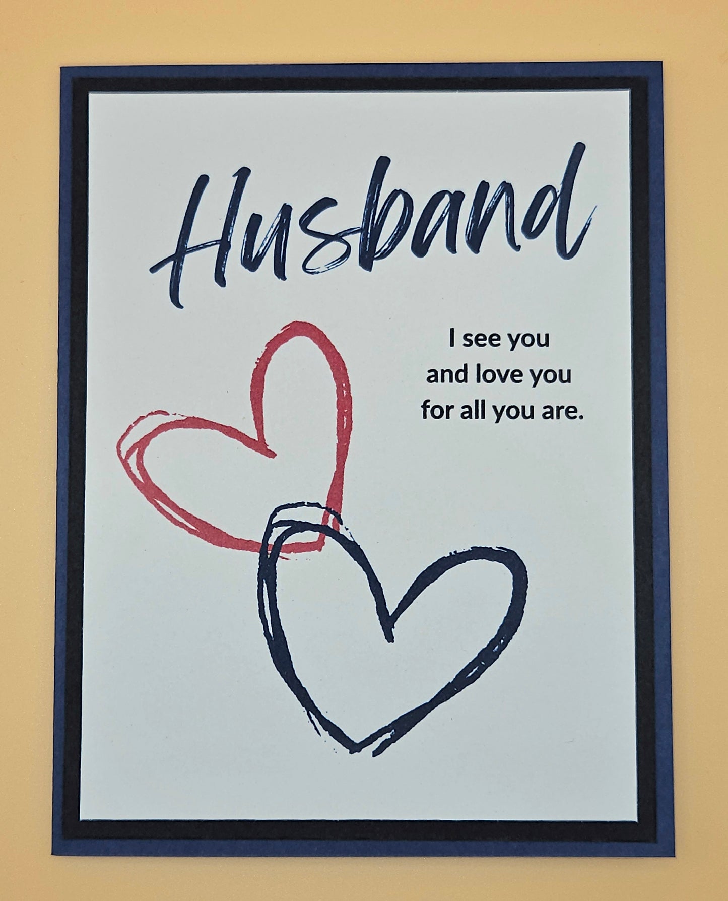 Framed artwork with 'Husband' text and hearts on a beige background