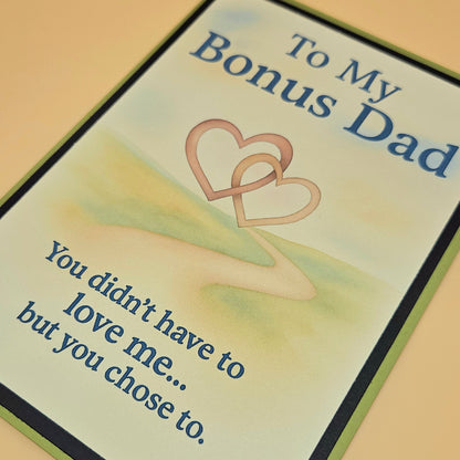 Greeting card for 'Bonus Dad' with two interlocking hearts and a message.