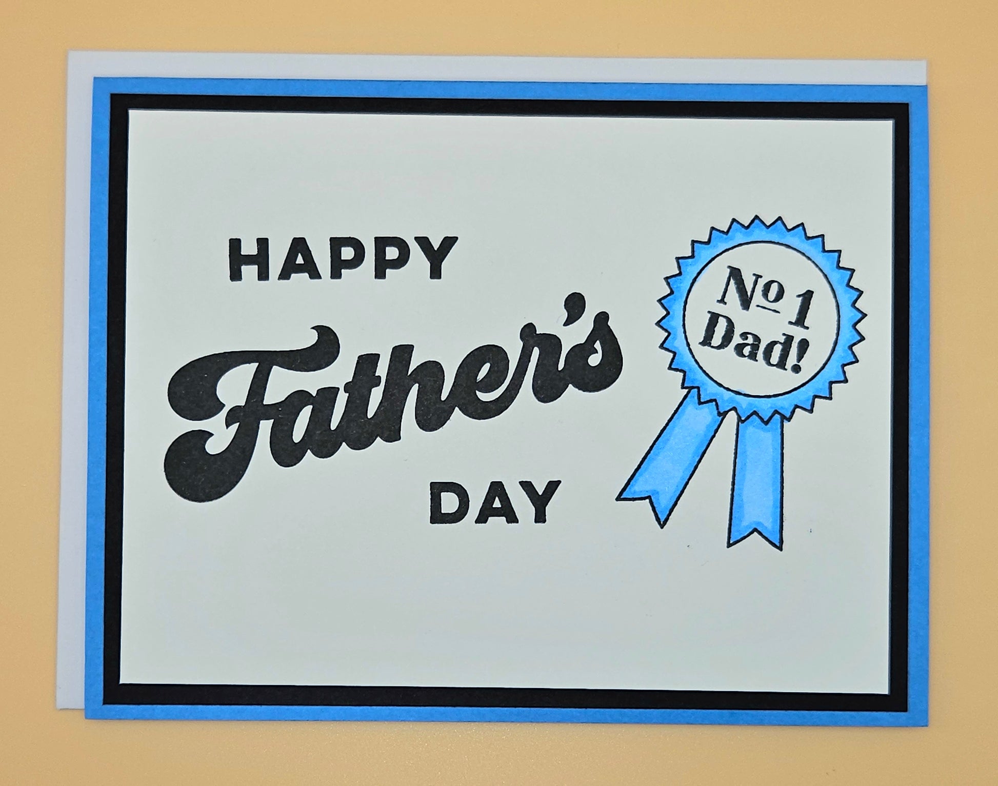 Father's Day card with 'Happy Father's Day' text and a blue ribbon badge on a beige background