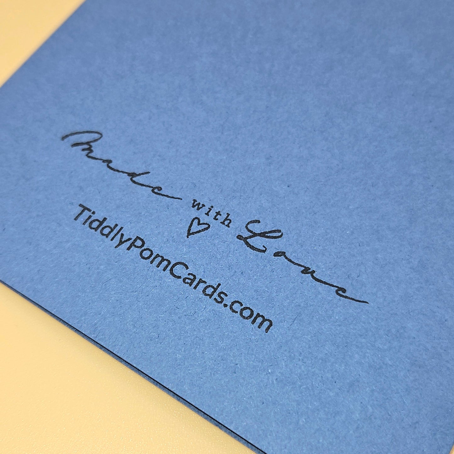 Blue card with 'Made with Love' text and website URL on a yellow background