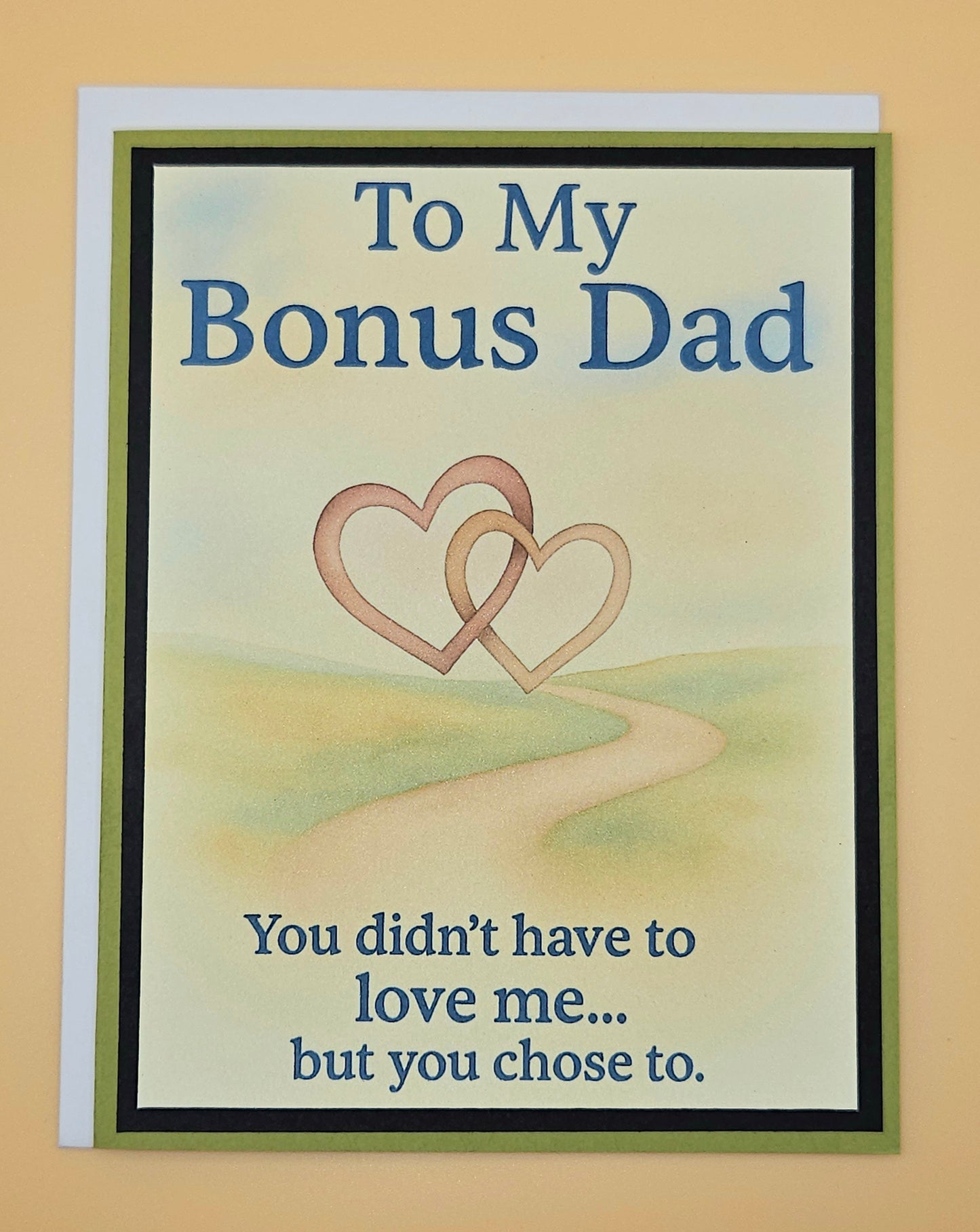 Card for a bonus dad with two interlocking hearts and text on a beige background