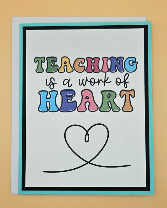 Card with 'Teaching is a work of heart' text and a heart symbol on a beige background