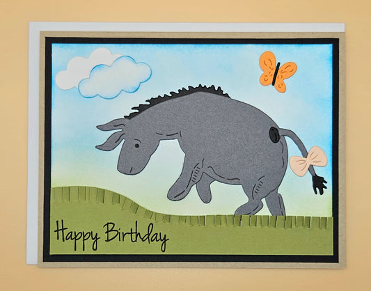 Handmade birthday card with a donkey and butterfly design on a beige background