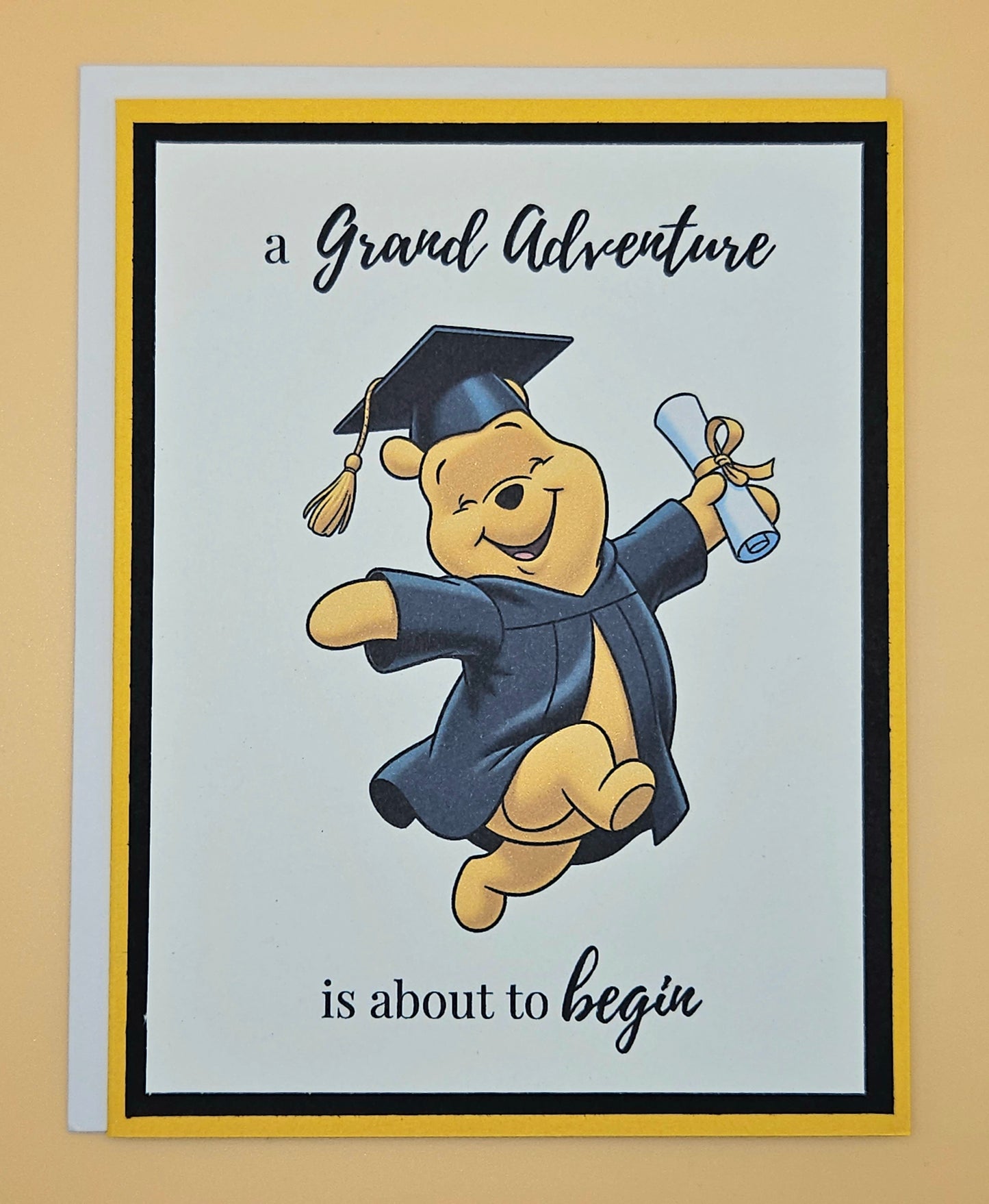 Graduation-themed card with a cartoon bear in a cap and gown on a beige background