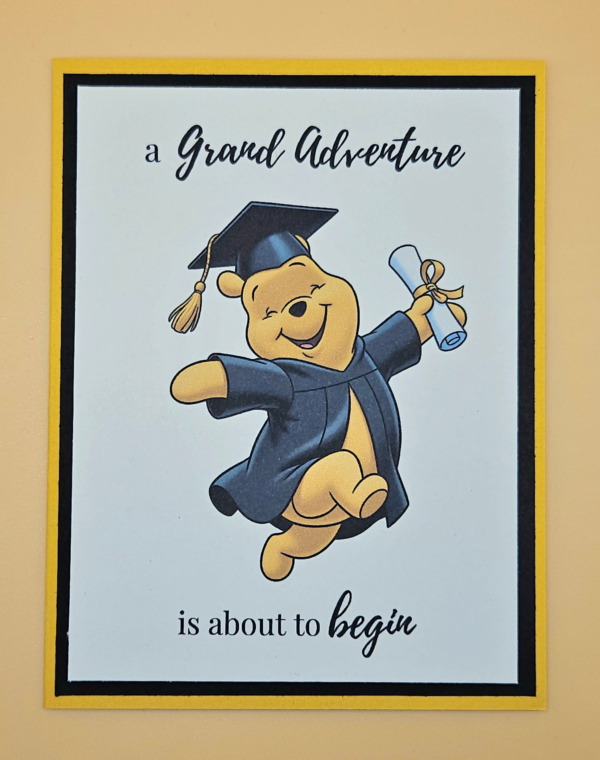 Cartoon bear in graduation attire with text 'A Grand Adventure is about to begin' on a light blue background.