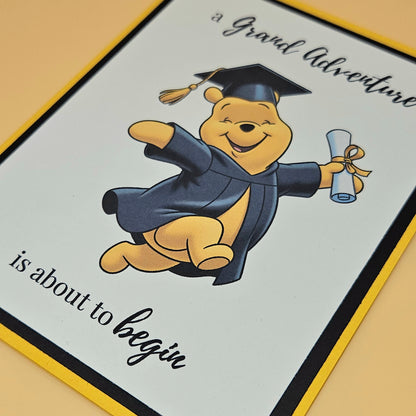 Graduation-themed card with a cartoon bear in a cap and gown holding a diploma.
