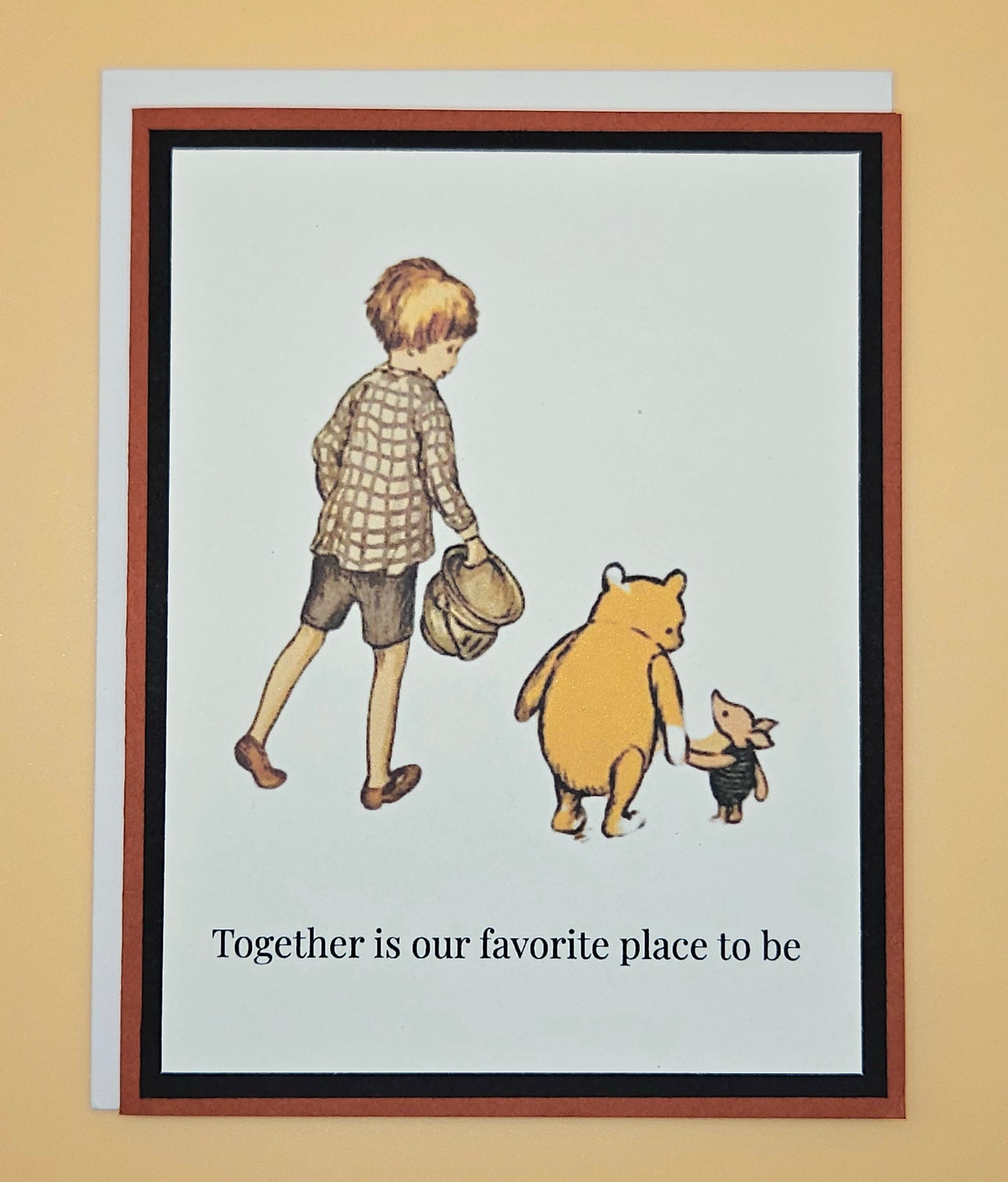 Handmade Winnie the Pooh friendship card featuring classic Christopher Robin Pooh and Piglet walking together illustration with warm rust-red and black layered cardstock frames