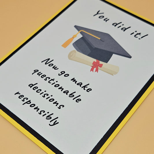 Graduation-themed card with cap, diploma, and humorous text on a beige background. Tiddly Pom Cards
