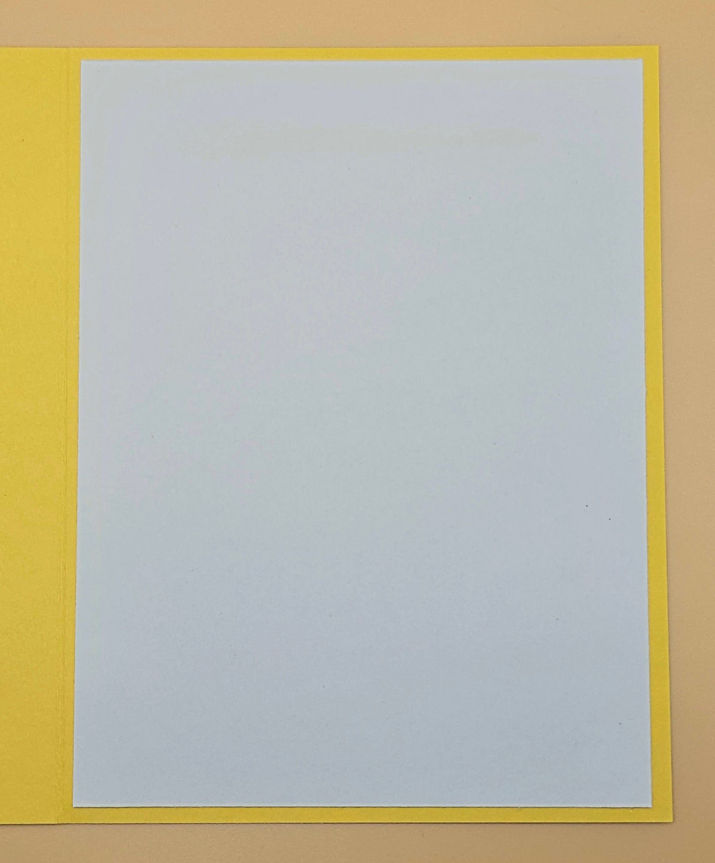 White sheet of paper with a yellow border on a beige background
