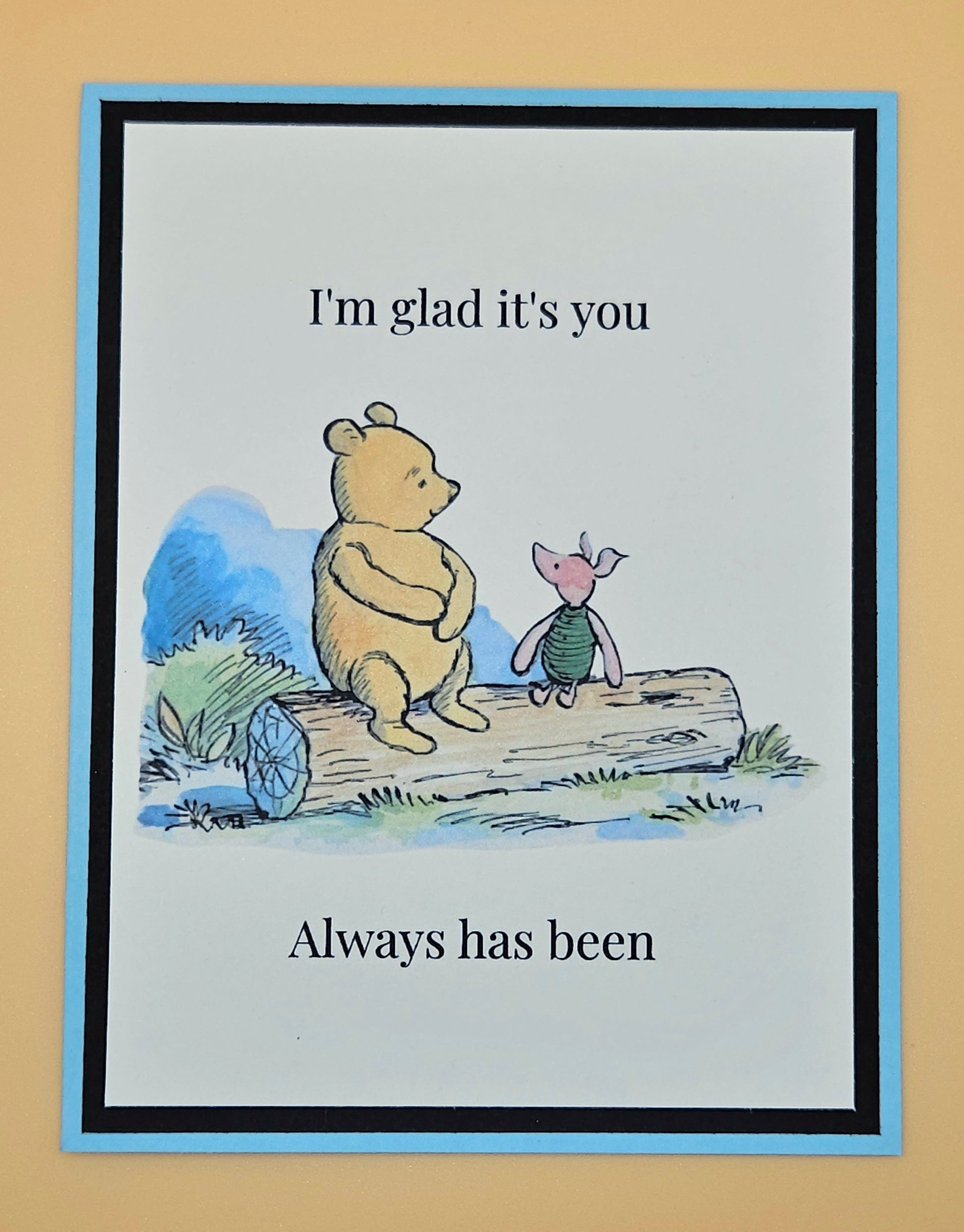 Handmade Winnie the Pooh and Piglet friendship card with Pooh and Piglet sitting on a log in watercolor style on white inner panel with black and sky blue border. Text reads I'm glad it's you always has been.
