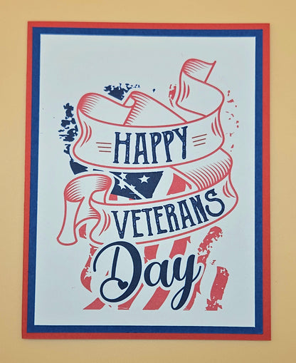 Handmade Veterans Day card with bold patriotic ribbon banner and stars and stripes design on white inner panel with black navy and red borders. Text reads Happy Veterans Day. TiddlyPomCards.com