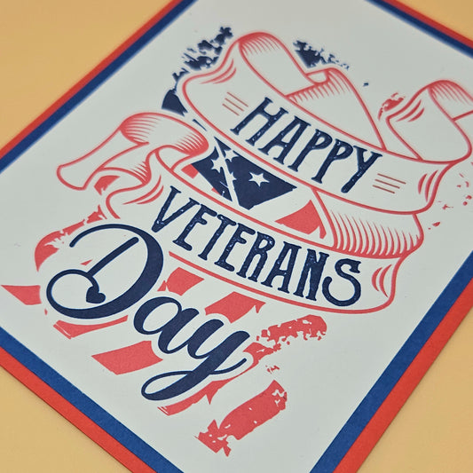 Handmade Veterans Day card with bold patriotic ribbon banner and stars and stripes design on white inner panel with black navy and red borders. Text reads Happy Veterans Day. TiddlyPomCards.com
