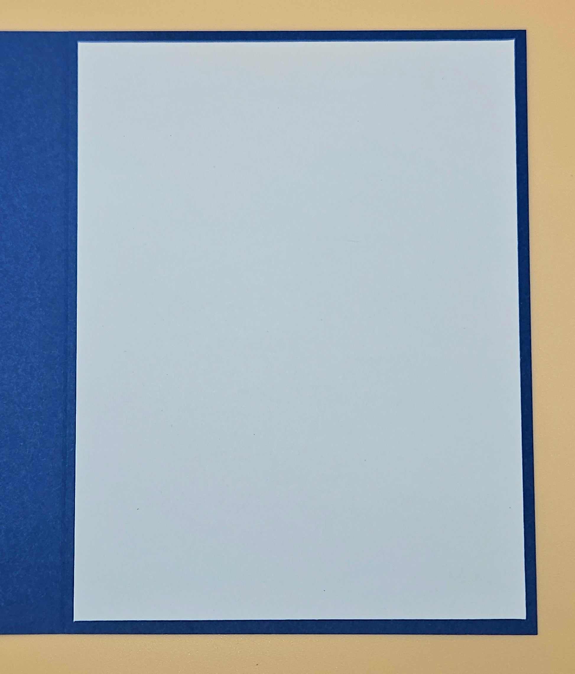 Plain light blue sheet of paper with a dark blue border on a beige background