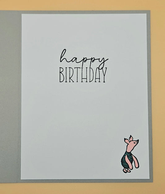 Birthday card with 'happy birthday' text and piglet on a gray background