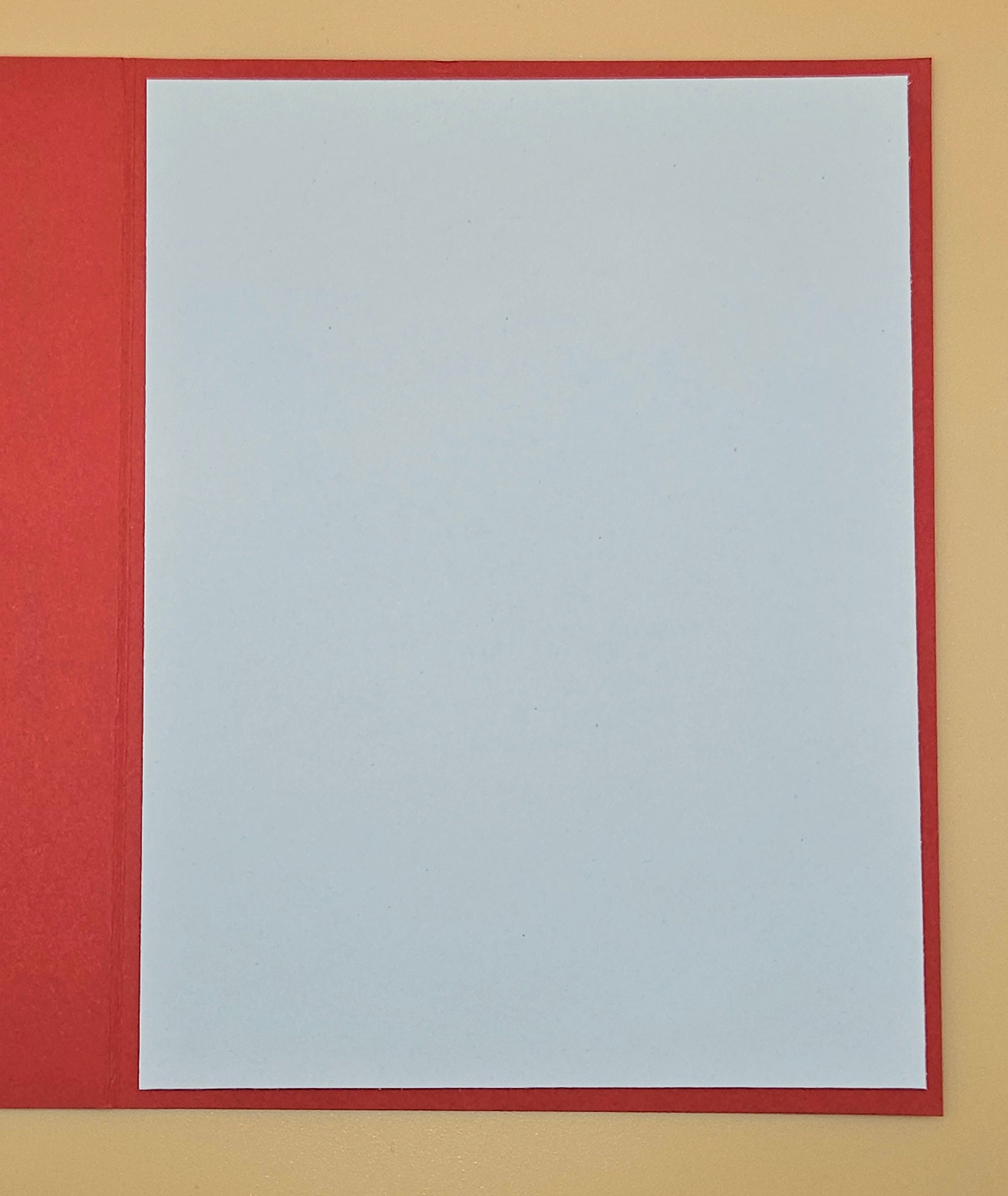 White sheet of paper with a red border on a beige background