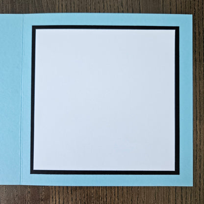 Light blue card with a white interior on a wooden surface