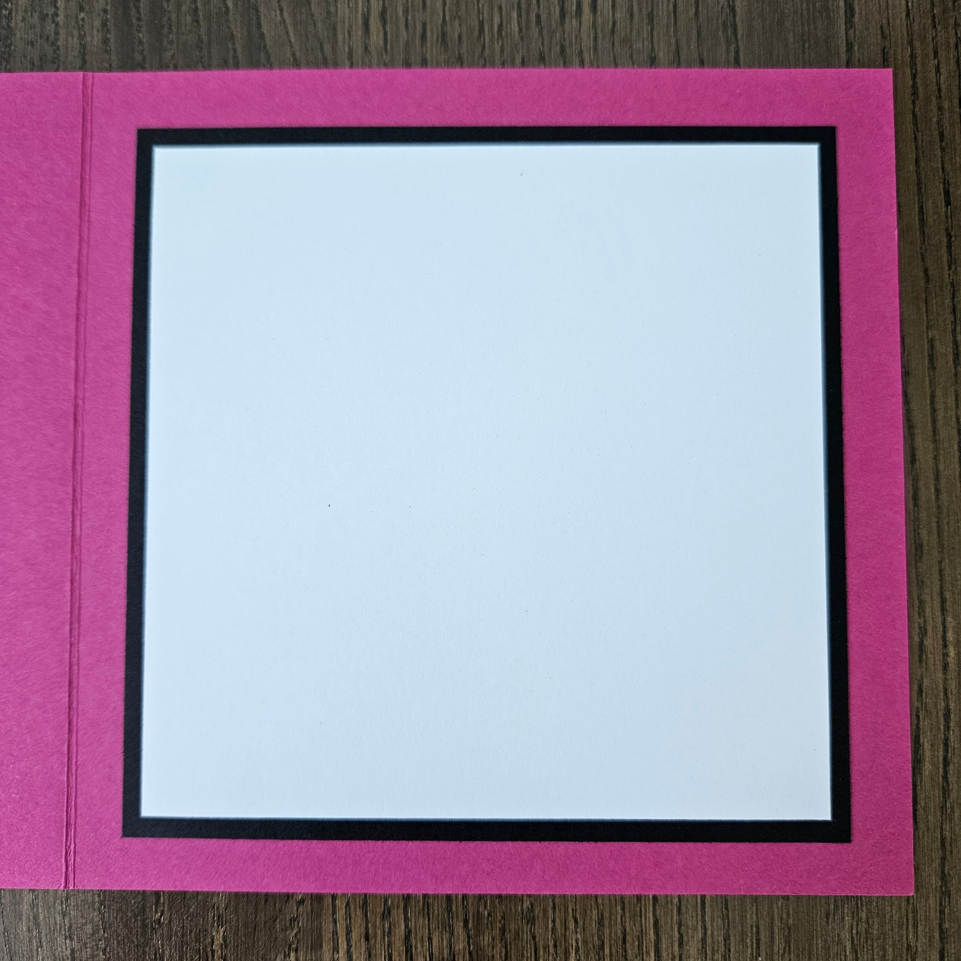 Pink border with a white center on a wooden surface