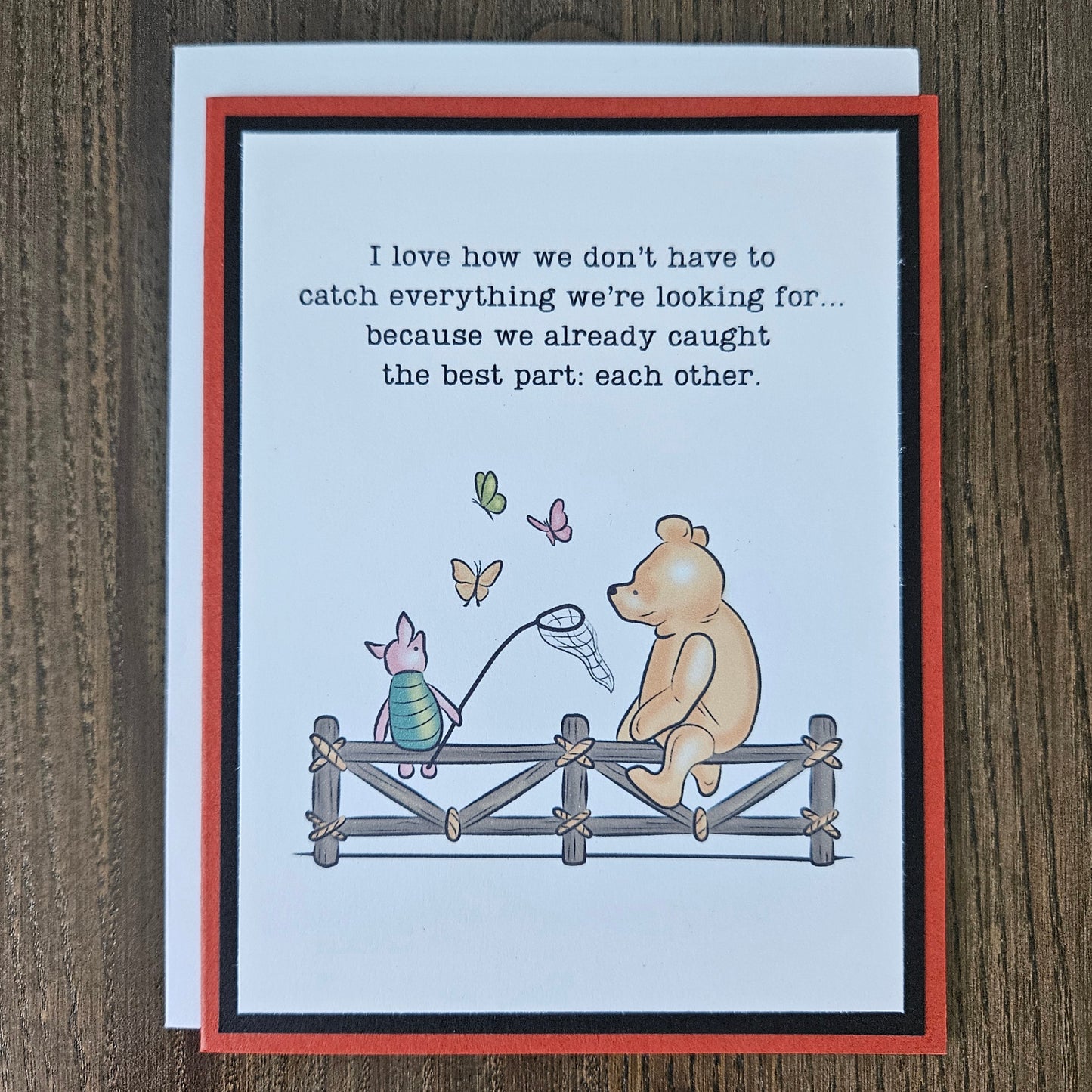 Handmade Winnie the Pooh friendship card featuring a classic storybook illustration of Pooh Bear and Piglet sitting together on a rustic wooden fence watching butterflies, finished with layered cardstock frames.