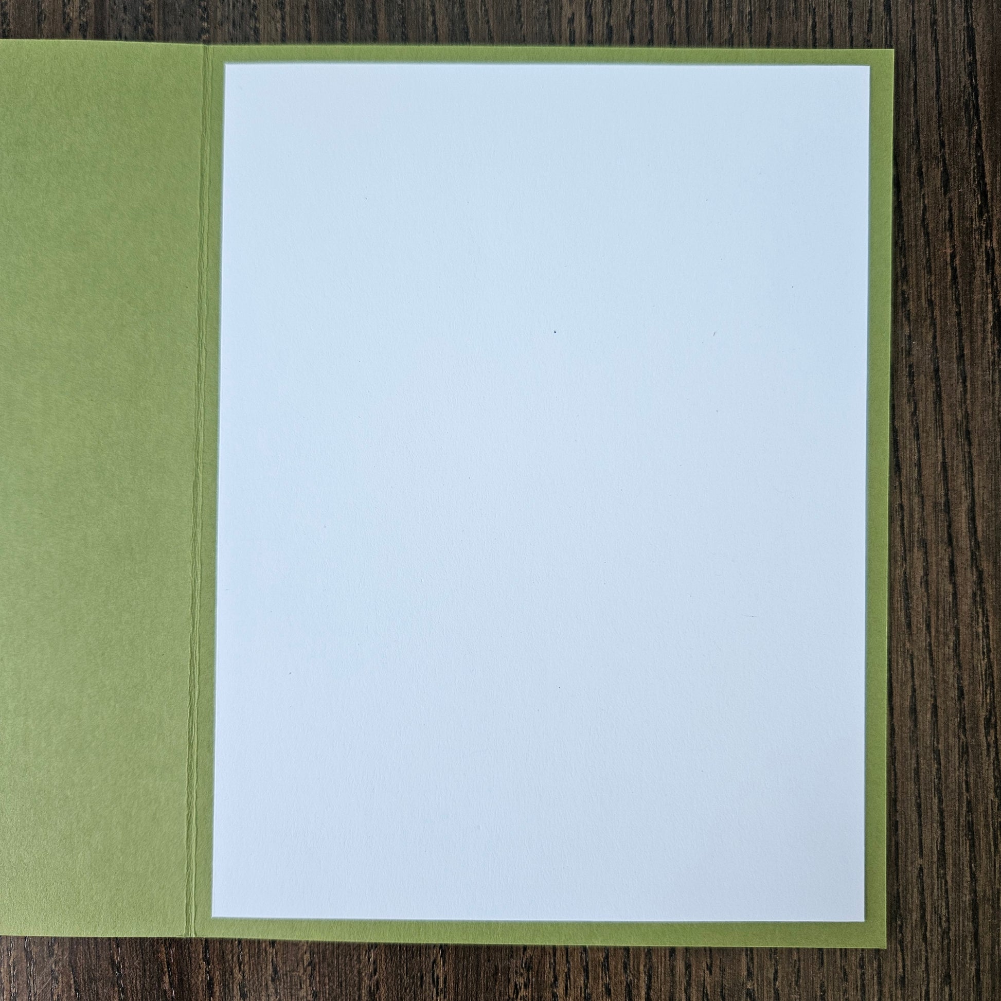 White card with green border on a wooden surface