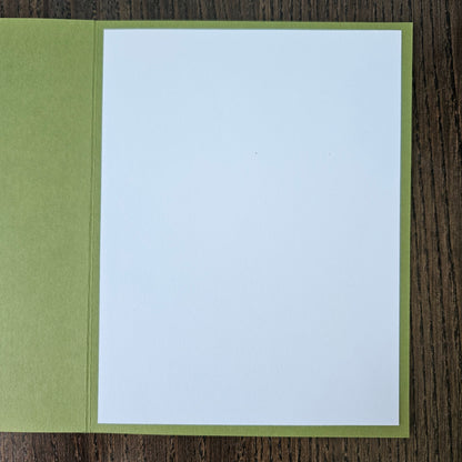 White card with green border on a wooden surface