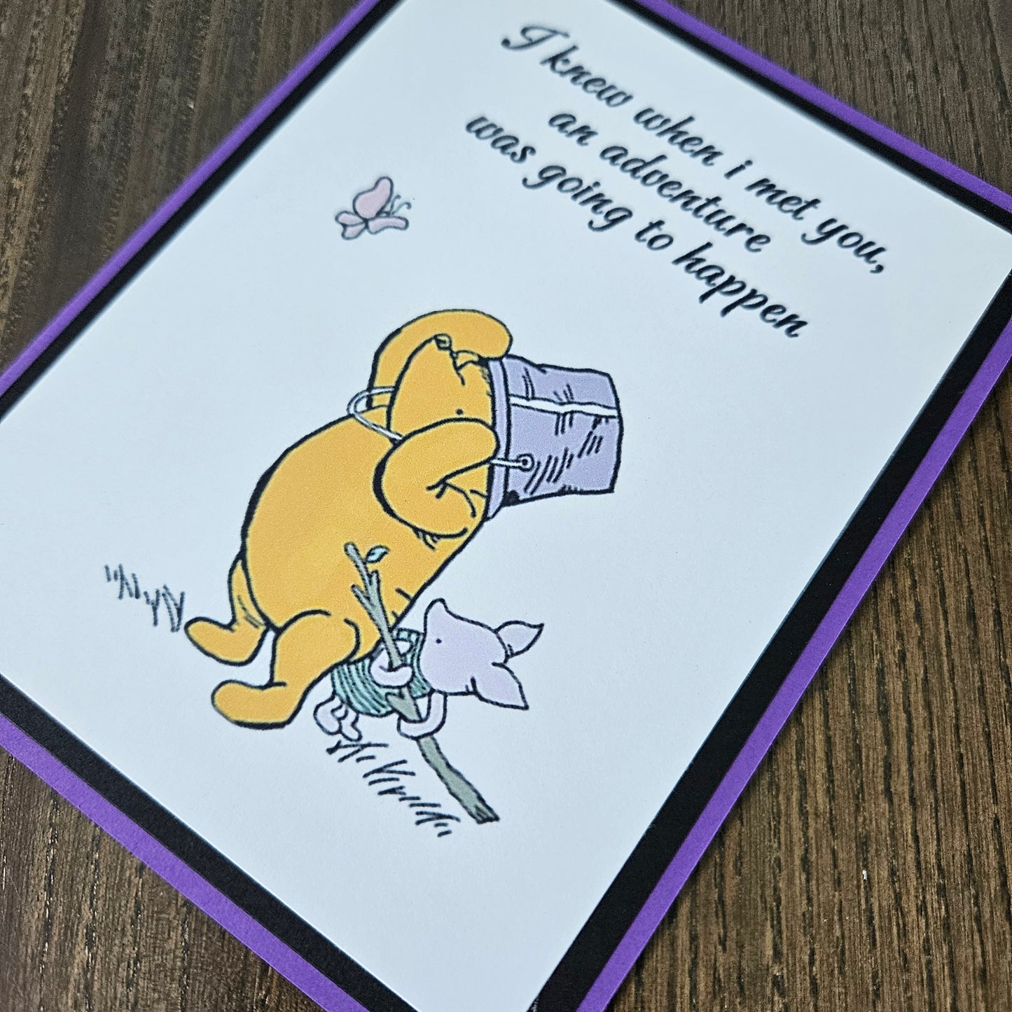 Cartoon character with a purple hat and a small animal on a card with text.
