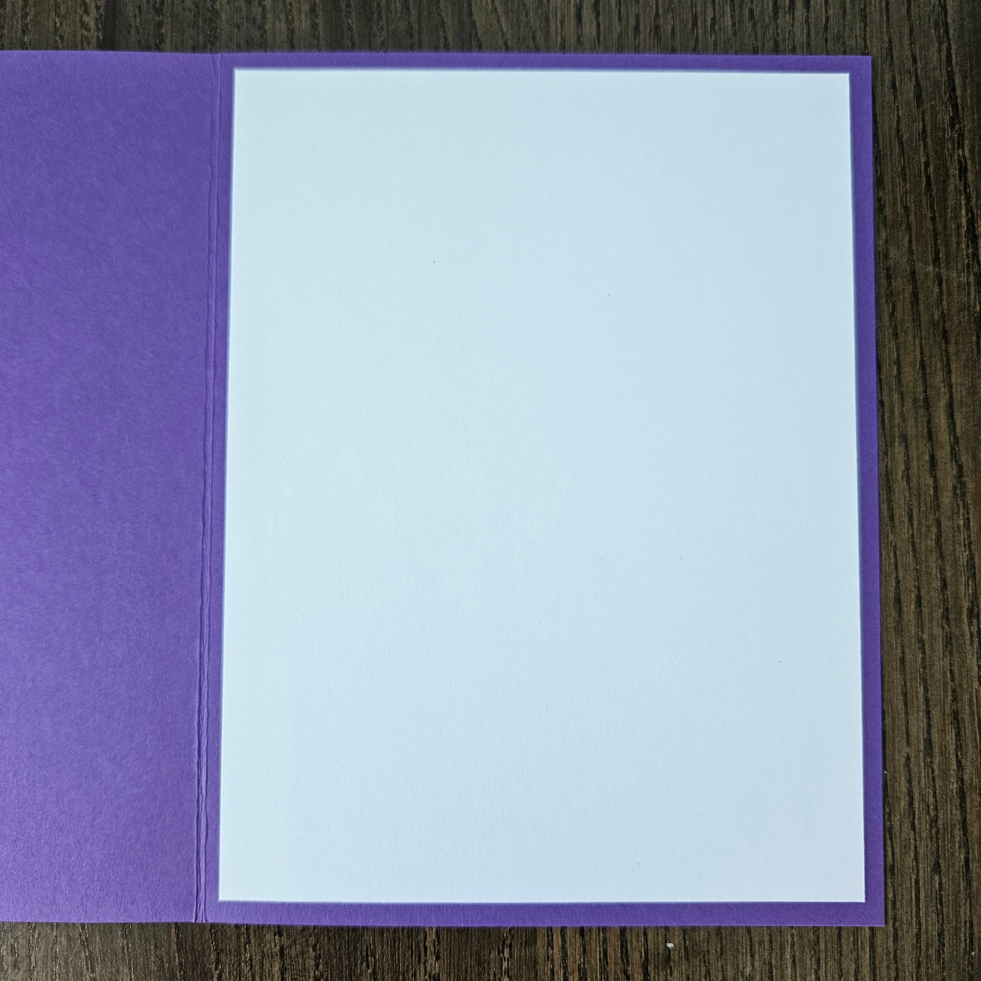 Purple card with a white center on a wooden surface