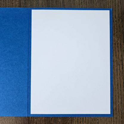 Blue pocket folder with a white sheet of paper inside on a wooden surface