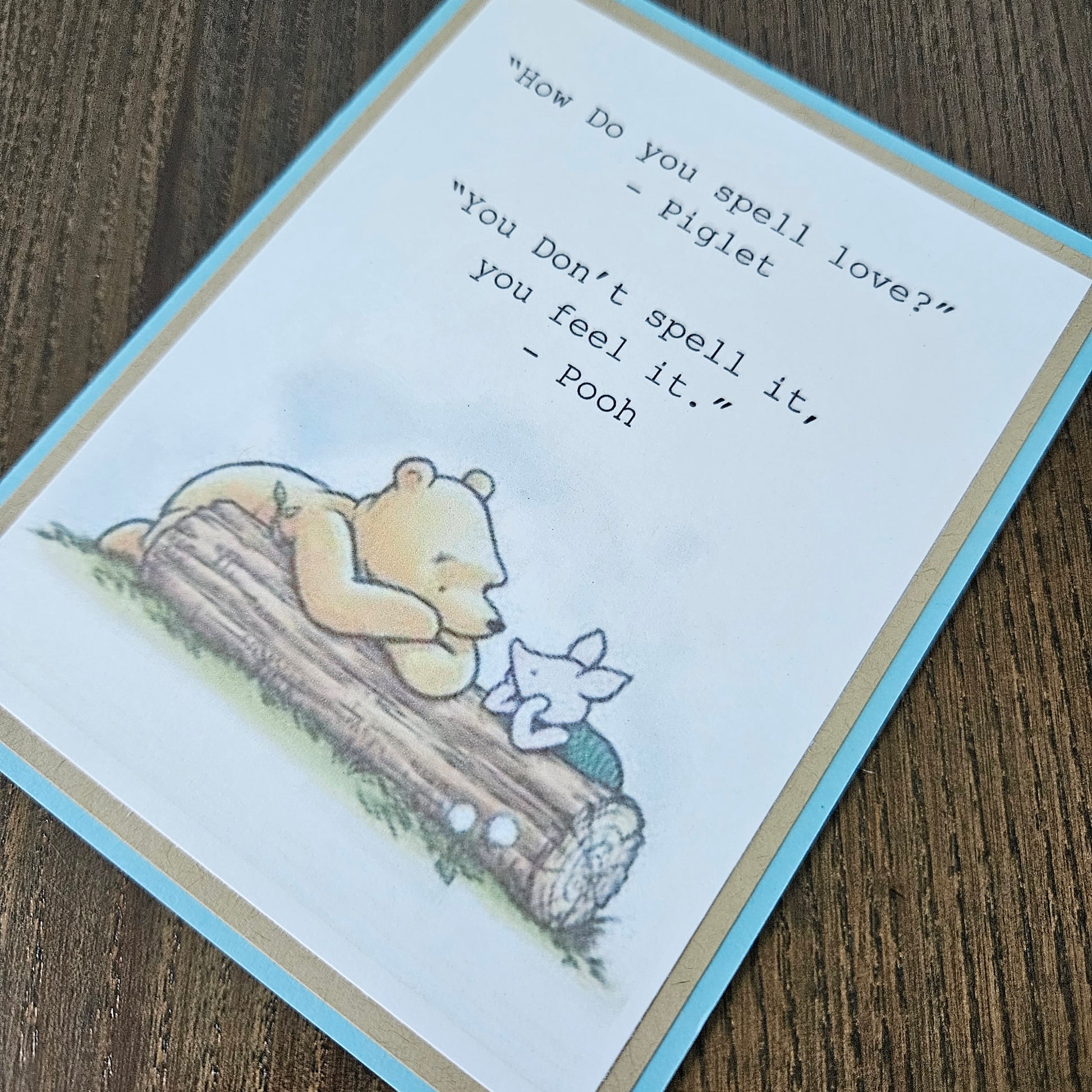Card with Winnie the Pooh and Piglet sitting on a log, featuring a quote between them.