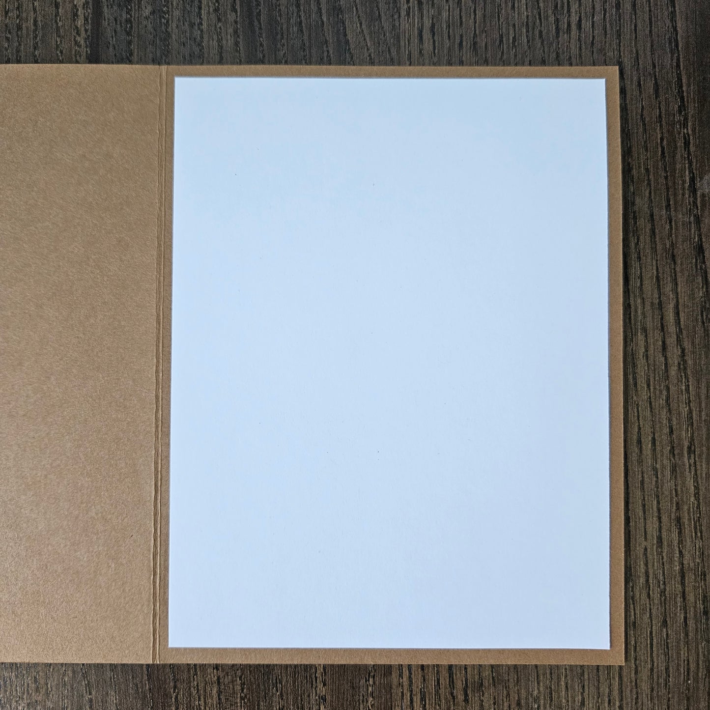 White card with brown border on a wooden surface