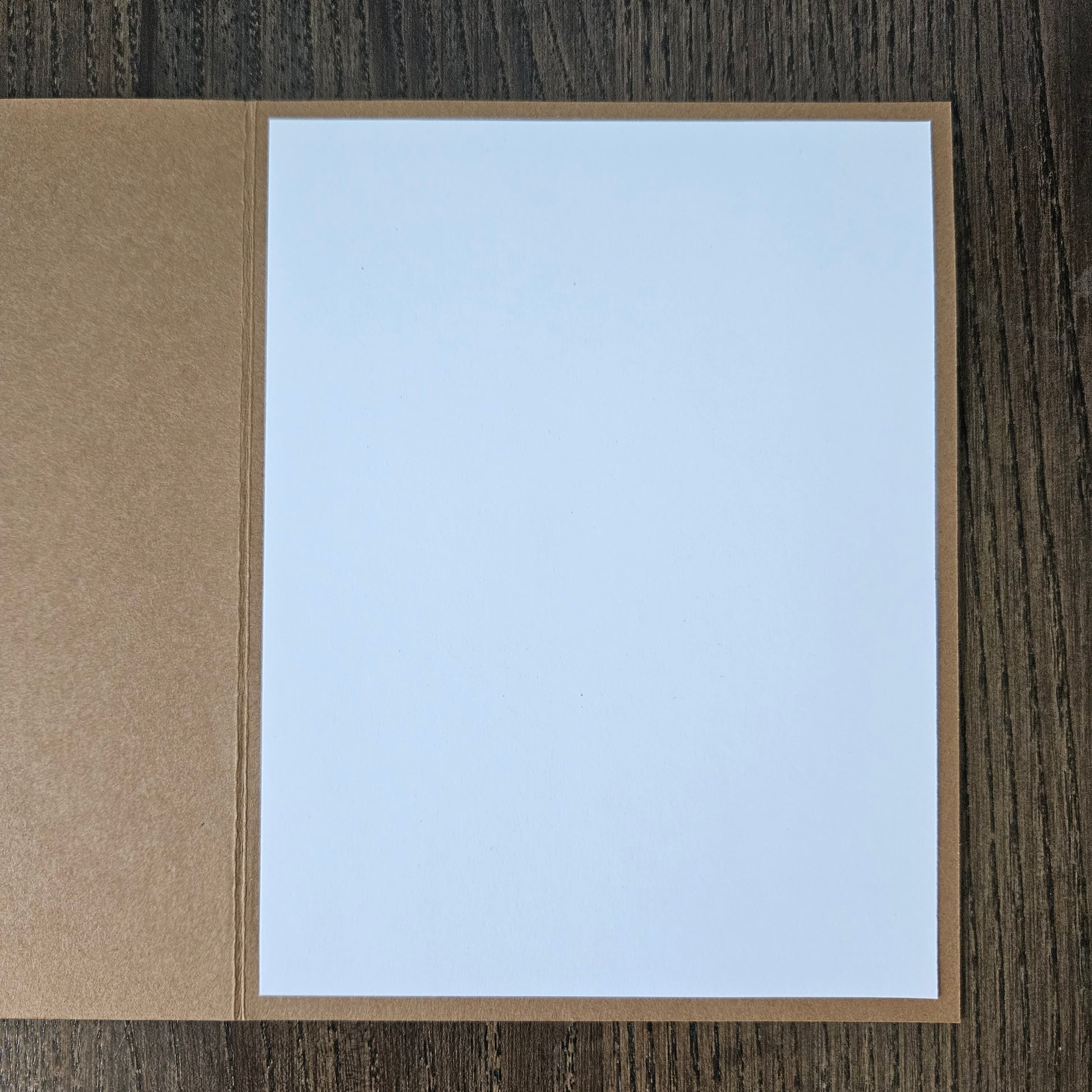 White card with brown border on a wooden surface