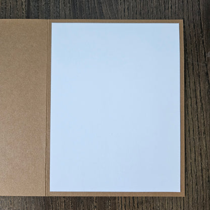 White card with brown border on a wooden surface
