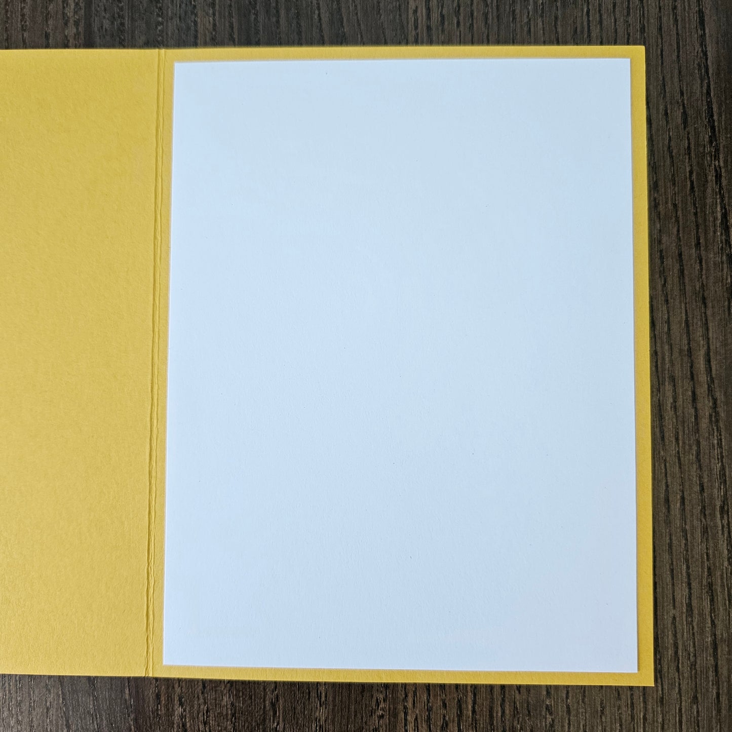 Two-toned card with light blue top and mustard yellow bottom on a wooden surface