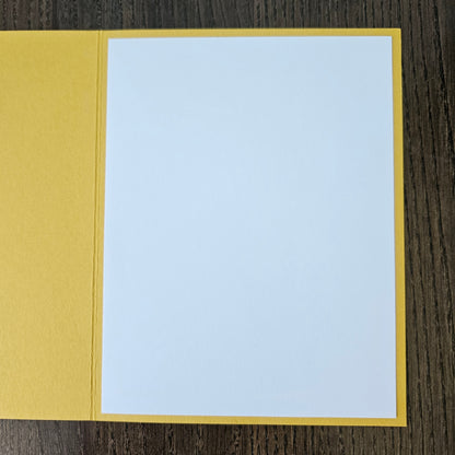 Two-toned card with light blue top and mustard yellow bottom on a wooden surface