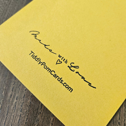 Yellow card with 'Made with Love' and TiddlyPomCards.com text on a wooden surface
