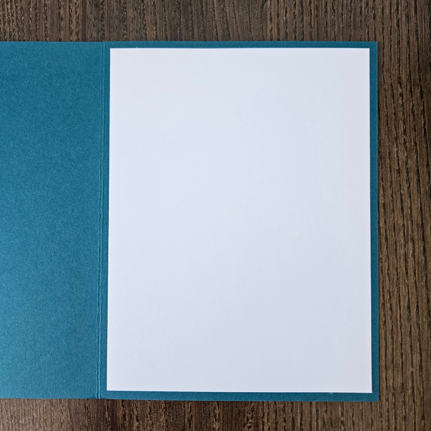 Blue card with white interior on a wooden surface