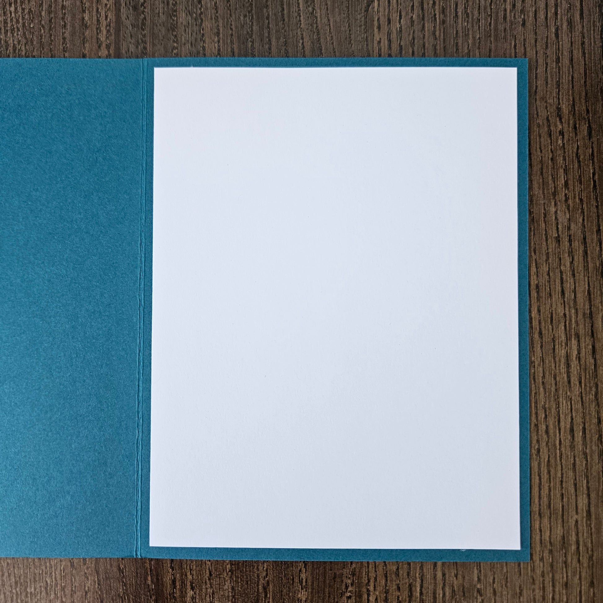 Blue card with white interior on a wooden surface