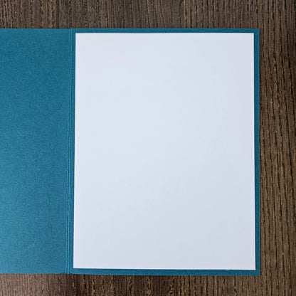 Blue card with white interior on a wooden surface