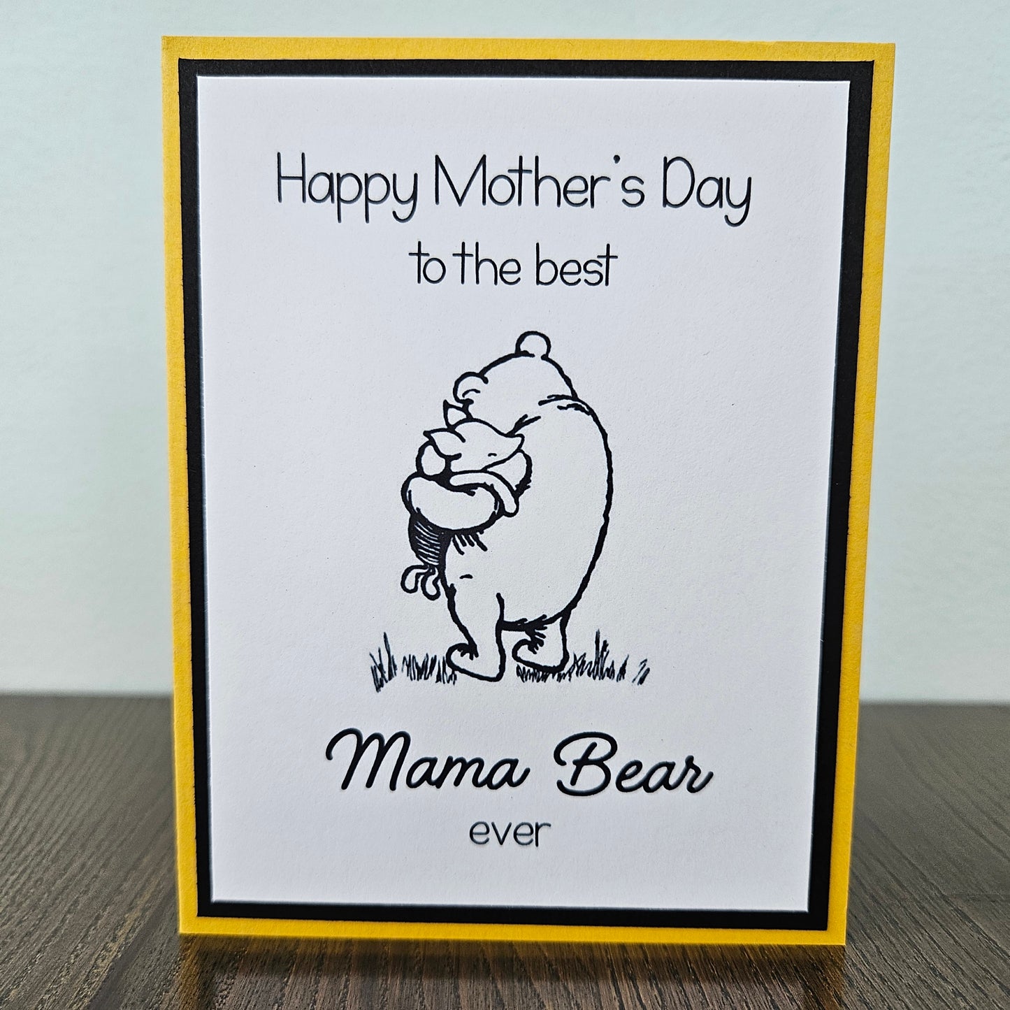 Winnie The Pooh Mother's Day card with text 'Happy Mother's Day to the best Mama Bear ever' on a beige background.