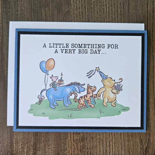 Greeting card with cartoon animals and birthday-themed text on a wooden surface