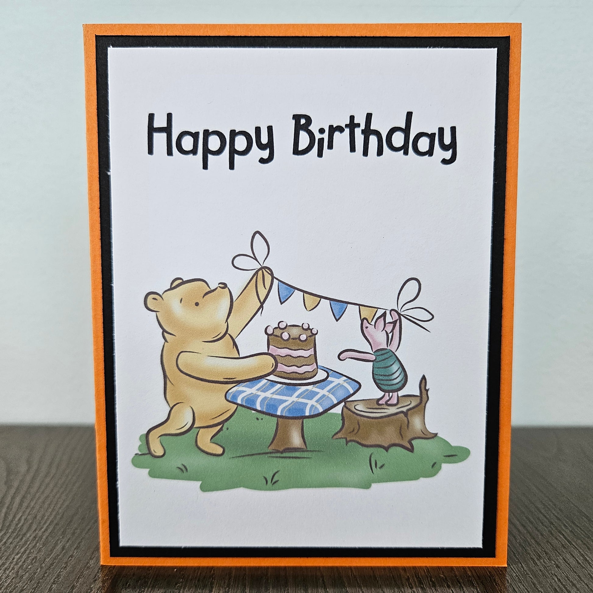 Birthday card with a bear and rabbit celebrating a birthday, featuring a cake and flags.